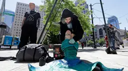 Victoria Lemeow bersiap jelang aksi menolak penangkapan ikan di Seattle, AS, Senin (5/6). Victoria Lemeow dikait selama satu jam sebagai bentuk empati kepada ikan saat mereka ditangkap untuk dikonsumsi manusia. (AP Photo / Elaine Thompson)