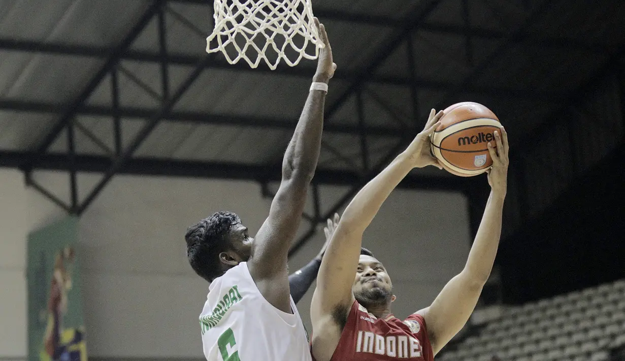 Pebasket Indonesia, Adhi Pratama saat melakukan lay up dan coba dihalang pemain India Annadurai Aravind pada final Invitation Tournament Asian Games di GBK Hall Basket, Jakarta. Indonesia menang 78-68. (Bola.com/Peksi Cahyo)