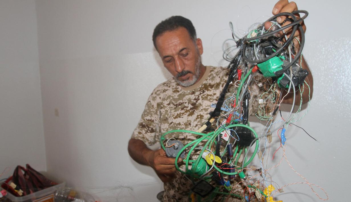 Anggota militer Libya menjinakkan bom rakitan milik militan ISIS di Sirte (5/9). Setelah berhasil menaklukkan salah satu markas ISIS, Militer Libya menemukan bom rakitan dan senjata peledak lainnya yang masih aktif. (REUTERS/Hani Amara)