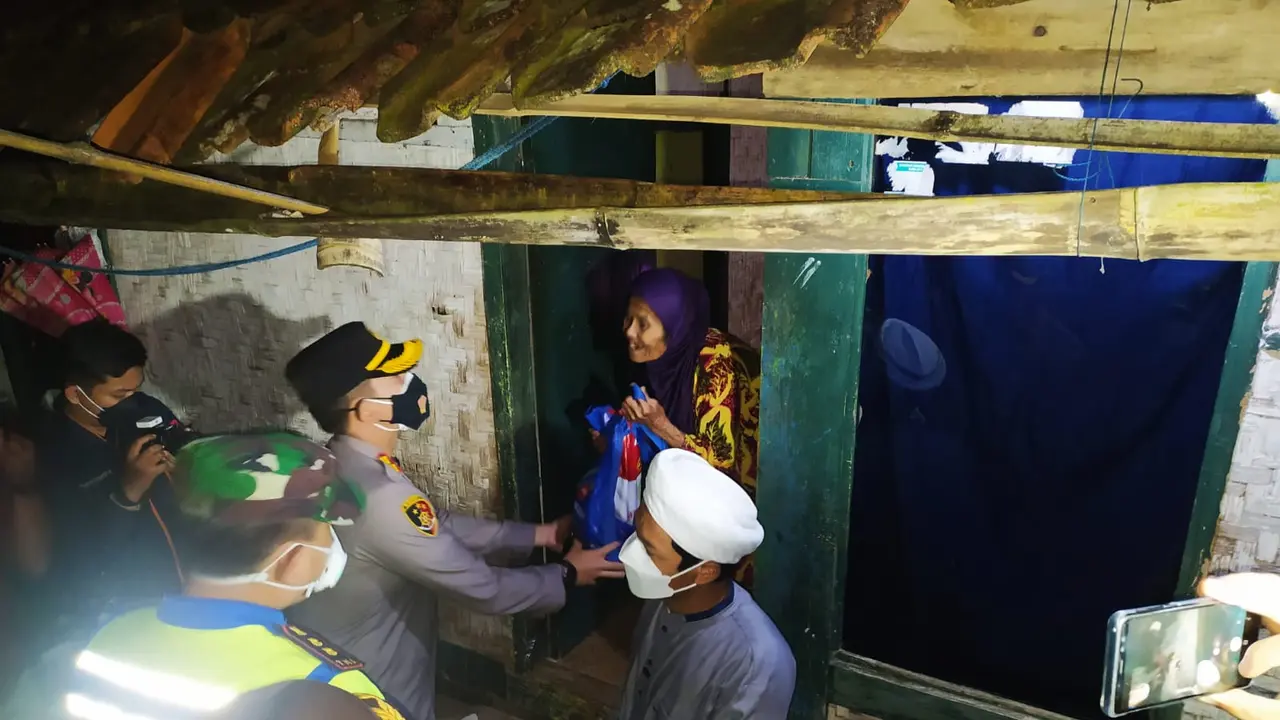 Wakil Ketua Satgas Covid-19 AKBP Wirdhanto didampingi Dandim 0611 Garut Letkol Deni Iskandar tengah memberikan bingkisan bantuan sosial sembako bagi warga miskin di kampung Batu Susun, Desa Sukahati Kecamatan Cilawu, Garut, Jawa Barat.