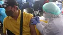 Vaksinator menyuntikkan vaksin COVID-19 kepada sopir angkutan kota di Terminal Poris Plawad, Cipondoh, Kota Tangerang, Kamis (4/3/2021). Ada sebanyak 1.000 peserta pekerja transportasi mulai dari sopir angkot, bus, taksi dan ojek yang divaksinasi Covid-19. (Liputan6.com/Angga Yuniar)