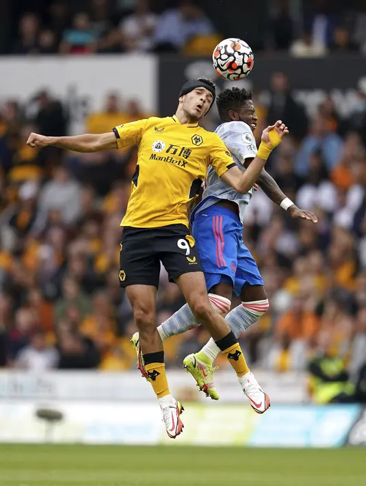 Penyerang Wolverhampton Wanderers Raul Jimenez (kiri) berebut bola dnegan gelandang Manchester United (MU) Fred pada match day ketiga Liga Inggris di Stadion Molineux, Minggu (29/8/2021). MU menang tipis 1-0 lewat gol Mason Greenwood. (Nick Potts/PA via AP)