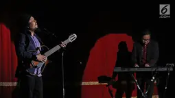 Ekspresi vokalis Payung Teduh, Is saat tampil dalam konser BBM x Liztomania vol.3 di Gedung Kesenian Jakarta, Selasa (14/11). Konser Musik Tanah Air Vol.3 ini bertajuk Payung Teduh "Catra Adhum". (Liputan6.com/Herman Zakharia)