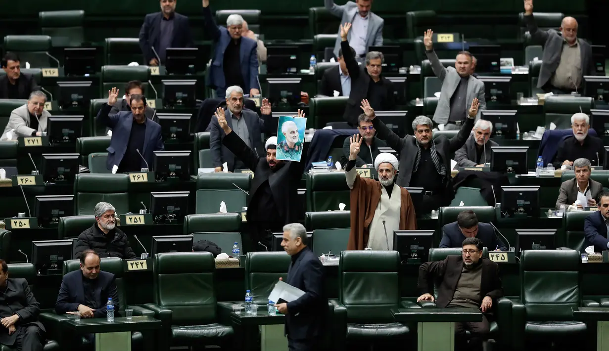 Anggota parlemen Iran mengangkat tangan saat voting RUU yang menetapkan pasukan militer Amerika Serikat sebagai teroris, Teheran, Selasa (7/1/2020). Parlemen Iran menetapkan pasukan militer Amerika Serikat teroris sebagai tanggapan atas kematian Jenderal Qasem Soleimani. (AP Photo/Vahid Salemi)