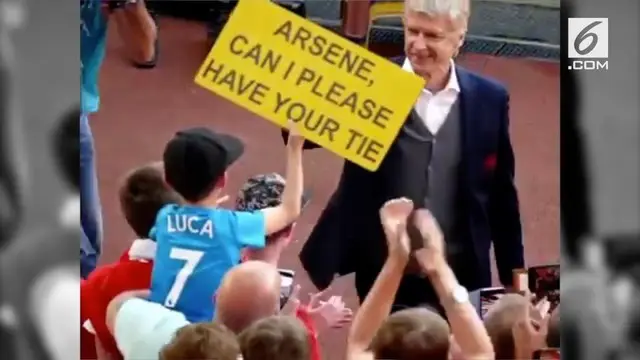 Arsene Wenger memberikan dasi sebagai kenang-kenangan untuk fans cilik Arsenal pada pertandingan terakhirnya di Emirates Stadium.