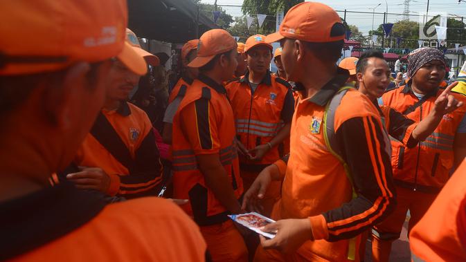Petugas Penangganan Prasarana dan Saran Umum (PSSU) atau pasukan oranye mengantre sembako gratis di Jakarta, Jumat (3/8). Pembagian sembako gratis tersebut dalam rangka menyambut HUT ASABRI ke-47 tahun. (Merdeka.com/Imam Buhori)