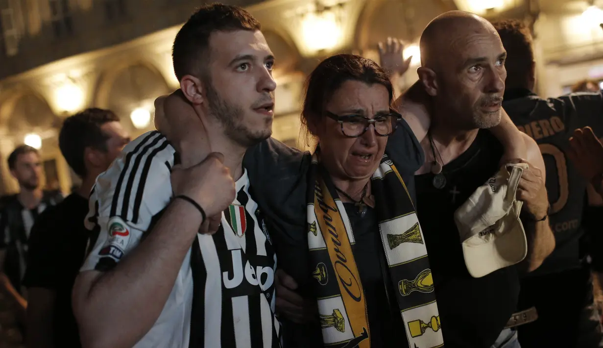 Seorang wanita dievakuasi usai terjadi ledakan saat nonton bareng final Liga Champions di Piazza San Carlo, Turin, Sabtu (3/6/2017). Acara nobar dipadati sekitar 20.000 supporter Juventus. (AFP/Marco Bertorello)