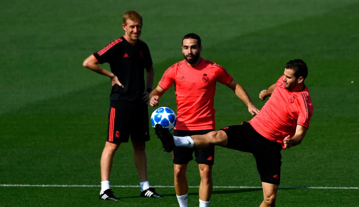 Bek Real Madrid, Dani Carvajal (tengah) bersama Nacho Fernandez (kanan) saat berlatih di Madrid, Spanyol, Selasa (18/9). Los Blancos akan mempertahanan mahkota Eropa melawan AS Roma pada laga pembuka Grup G Liga Champions. (GABRIEL BOUYS/AFP)