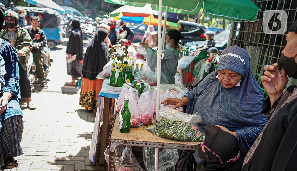 Penjual menata bunga tabur di TPU Karet Tengsin, Jakarta, Minggu (27/3/2022). Sebagian warga memanfaatkan waktu jelang Ramadan menjadi penjual bunga tabur musiman untuk memenuhi kebutuhan ziarah ke makam yang dijual Rp 5.000 - Rp 20.000 per kantong plastik. (Liputan6.com/Faizal Fanani)