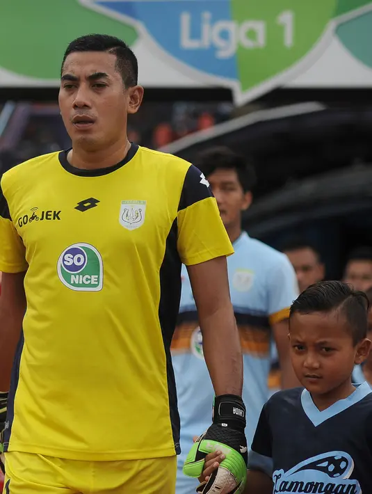 Kiper Persela Lamongan Choirul Huda berjalan menuju lapangan sebelum pertandingan antara Persela Lamongan dan Semen Padang dalam Liga 1 di stadion Surajaya, Lamongan (15/10). (AFP Photo/Juni Kriswanto)