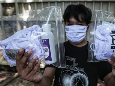 Anggota Pewarta Foto Indonesia Jakarta (PFIJ) menunjukkan paket penunjang liputan di Jakarta, Rabu (22/4/2020). PFIJ membagikan 230 paket penunjang liputan berupa masker, hand sanitizer, dan multivitamin kepada anggotanya yang melaksanakan tugas jurnalistik selama pandemi. (Liputan6.com/Johan Tallo)