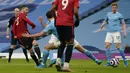 Bek Manchester United, Luke Shaw (kiri) melepaskan tendangan yang berbuah gol kedua timnya ke gawang Manchester City dalam laga lanjutan Liga Inggris 2020/21 di Etihad Stadium, Minggu (7/3/2021). MU menang 2-0 atas Mancity. (AFP/Dave Thompson/Pool)