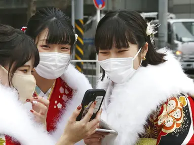 Para wanita berbaju kimono yang baru menginjak usia 20 tahun berfoto untuk merayakan Coming of Age Day di Yokohama, Jepang, Senin (10/1/2022). Coming of Age Day diadakan setiap tahun pada Senin kedua bulan Januari untuk merayakan remaja Jepang menjadi dewasa. (AP Photo/Koji Sasahara)