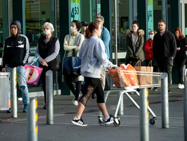 Orang-orang mengantre di luar supermarket ketika Selandia Baru akan beralih ke pembatasan level 3 di Hobsonville, Auckland, Rabu (12/8/2020). Selandia Baru akan memberlakukan lockdown di Auckland setelah ditemukan 4 kasus baru COVID-19 di kota itu. (Dean Purcell/New Zealand Herald via AP)