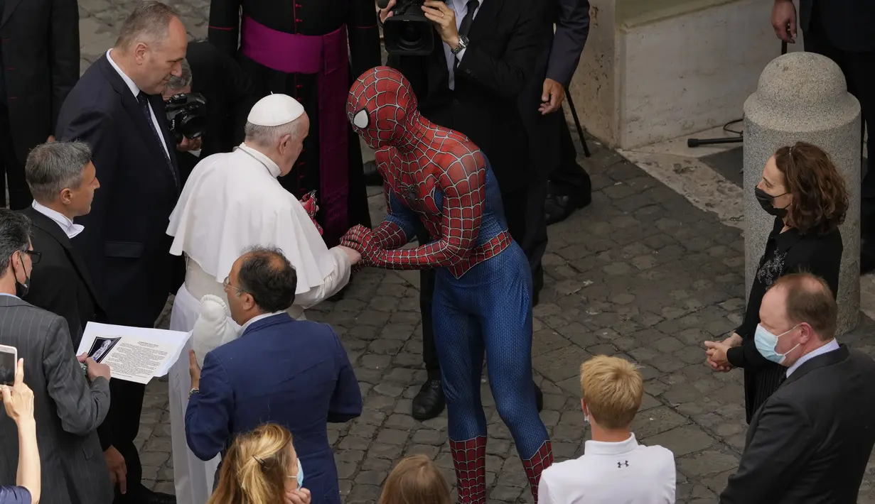 Paus Fransiskus bertemu Spider-Man pada akhir audiensi umum mingguan dengan jumlah umat terbatas di San Damaso Courtyard, Vatikan, Rabu (23/6/2021). Di akhir audiensi, pria tersebut diperkenalkan kepada Paus Fransiskus dan memberi masker Spider-Man miliknya. (AP Photo/Andrew Medichini)
