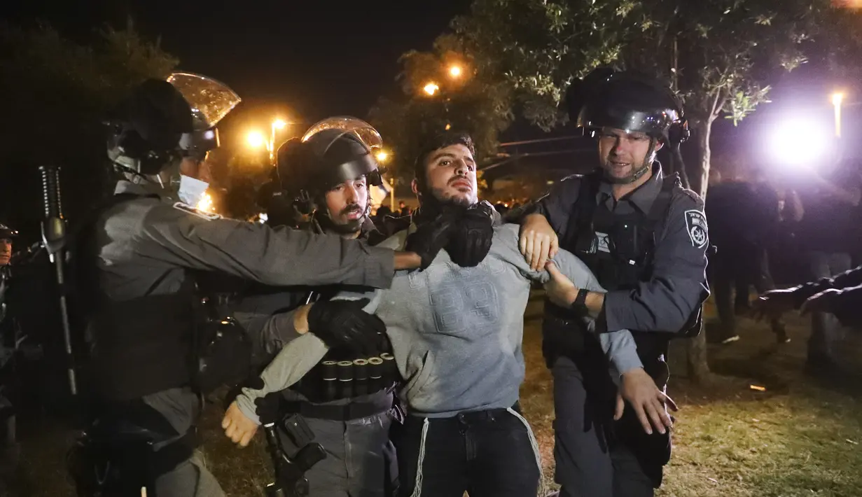 Polisi perbatasan Israel menahan pemuda Israel sebagai anggota "Lahava", sebuah kelompok ekstremis Yahudi, ketika mereka mencoba mendekati Gerbang Damaskus untuk memprotes di tengah ketegangan yang meningkat di kota itu, tepat di luar Kota Tua Yerusalem, Kamis (22/4/2021).  (AP Photo/Ariel Schalit)