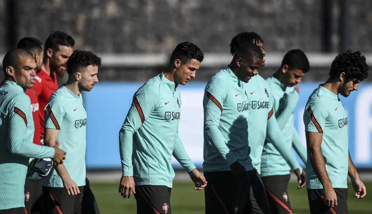 Penyerang Portugal, Cristiano Ronaldo (tengah) dan rekan satu timnya menghadiri sesi latihan di tempat latihan Cidade do Futebol di Oeiras (10/11/2021). Portugal akan bertanding melawan Irlandia pada Grup A kualifikasi Piala Dunia 2022  di Aviva Stadium. (AFP/Patricia De Melo Moreira)