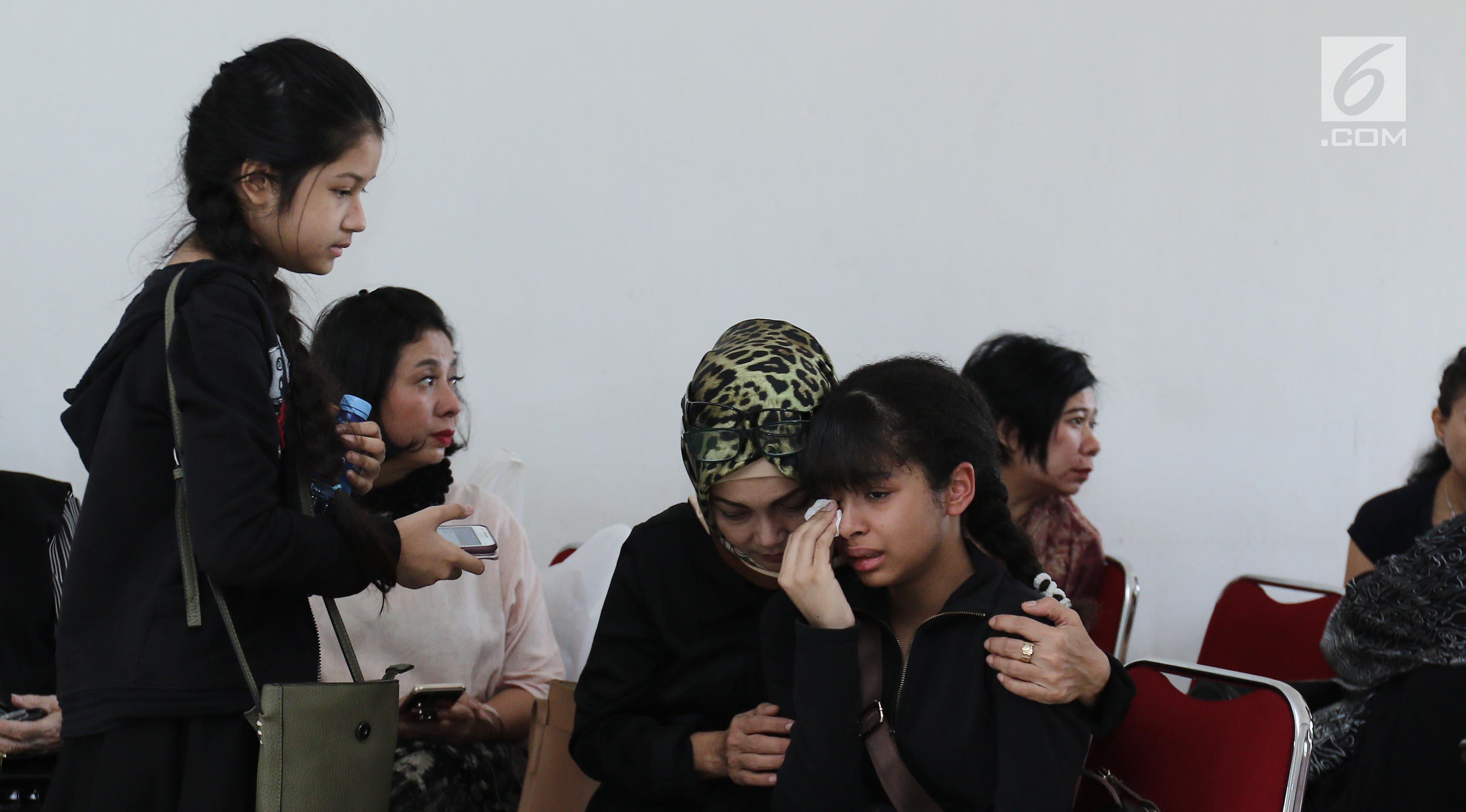 Putri Yana Zein, Aurelia Callista Carilla dan Alika Pandora Salvine menangis di dekat jenazah ibunya Yana Zein di rumah duka Fatmawati, Jakarta, Kamis (1/6). Yana Zein meninggal dunia pada usai 44 tahun. (Liputan6.com/Herman Zakharia)