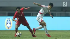 Pemain belakang Bahrain, Husain Sabba (kiri) berebut bola dengan bek Korea Utara, O Chol Hyok pada laga PSSI Anniversary Cup 2018 di Stadion Pakansari, Kab Bogor, Kamis (3/5). Laga dimenangkan Bahrain 4-1. (Liputan6.com/Helmi Fithriansyah)