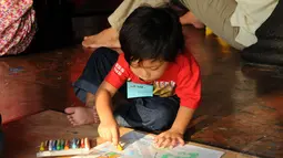 Salah satu anak menggambar di atas layang-layang buatannya di Museum Layang-Layang, Jakarta, (27/9/2014). (Liputan6.com/Helmi Fithriansyah)