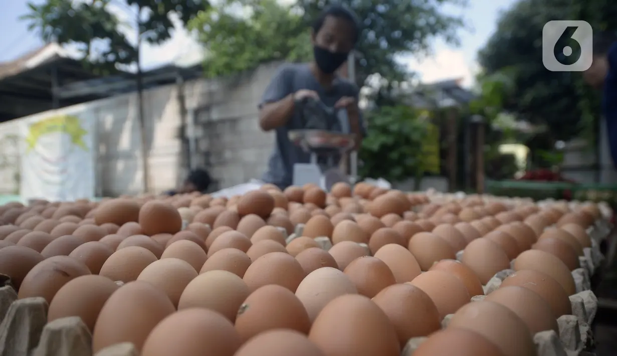 Pedagang menimbang telur saat melayani pembeli di pinggir jalan kasawan Perumahan Nusa Indah, Tangerang Selatan, Banten, Jumat (22/5/2020). Harga telur warna cokelat Rp 22 ribu per kilogram, sedangkan telur warna putih Rp 20 ribu per kilogram. (merdeka.com/Dwi Narwoko)