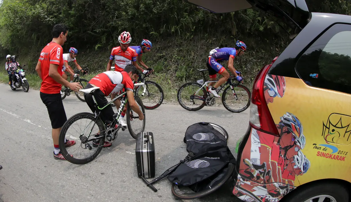 Kru Pishgaman Giant Team mengganti ban sepeda yang pecah di daerah perbukitan Alahan Panjang dalam Etape 4 Tour de Singkarak 2015, Selasa (6/10/2015). (Bola.com/Arief Bagus)
