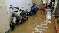 Anak-anak bermain banjir yang melanda kawasan Bidara Cina, Kecamatan Jatinegara, Jakarta Timur, Selasa (25/2/2020). Baru satu hari air surut, kawasan Bidara Cina yang bersebelahan dengan Kali Ciliwung kembali mengalami banjir. (merdeka.com/magang/ Muhammad Fayyadh)