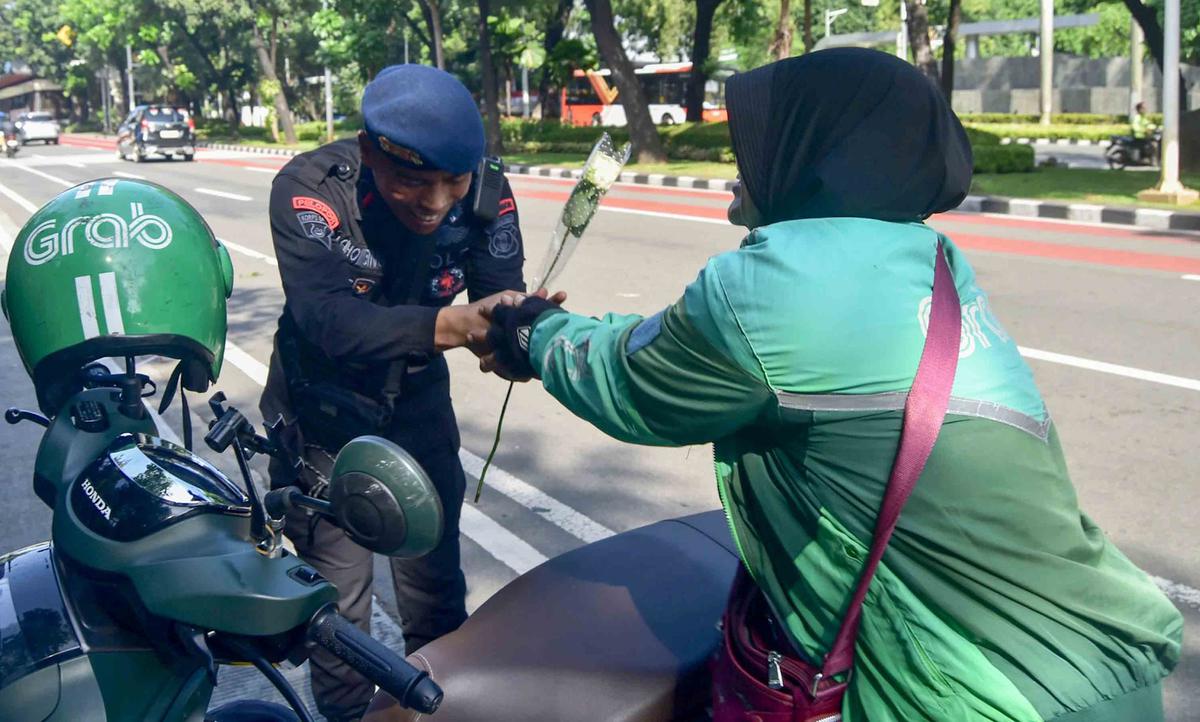 FOTO: Aksi Damai Ojol Tebar Mawar untuk Perdamaian