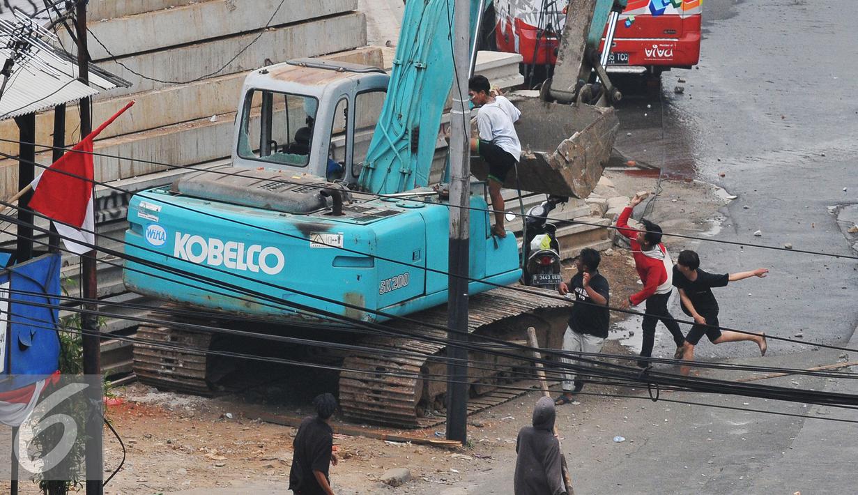 Sebuah alat berat di rusak massa saat kericuhan penggusuran Kampung Pulo, Jakarta, Kamis (20/8/2015). Penggusuran permukiman Kampung Pulo yang dilakukan oleh 2.200 personel gabungan untuk normalisasi Sungai Ciliwung. (Liputan6.com/Herman Zakharia)