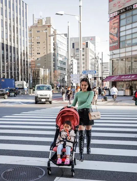 Tetap tampil stylish sambil dorong stroller, Shandy Aulia pakai atasan simpel berwarna sage pastel yang lembut. @shandyaulia.