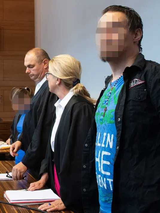 Terdakwa Berrin T (kiri) dan Christian L (kanan) bersama pengacara mereka menunggu sidang putusan di pengadilan distrik di Freiburg, Jerman, Selasa (7/8). Berrin dan Christian menyerang putranya secara seksual lebih dari dua tahun. (THOMAS KIENZLE/AFP)