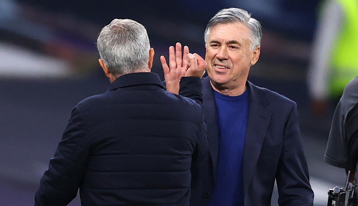Pelatih Tottenham Hotspur, Jose Mourinho, menyapa pelatih Everton, Carlo Ancelotti, pada laga Premier League, Senin (6/7/2020). Mourinho rela langgar aturan jarak sosial demi memeluk Carlo Ancelotti. (AFP/Richard Heathcote)
