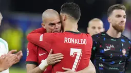 Pemain Portugal, Cristiano Ronaldo, memeluk Pepe untuk menenangkan rekannya tersebut yang sedang bersedih. (AP Photo/Hassan Ammar)