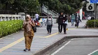 Sejumlah pekerja berjalan usai bekerja di Jalan Jenderal Sudirman, Jakarta, Selasa (10/5/2022). Pemerintah mengimbau masyarakat menerapkan bekerja dari rumah atau work from home (WFH) selama satu hingga dua pekan ke depan untuk mengantisipasi penyebaran virus corona COVID-19 usai libur Lebaran 2022. (Liputan6.com/Faizal Fanani)