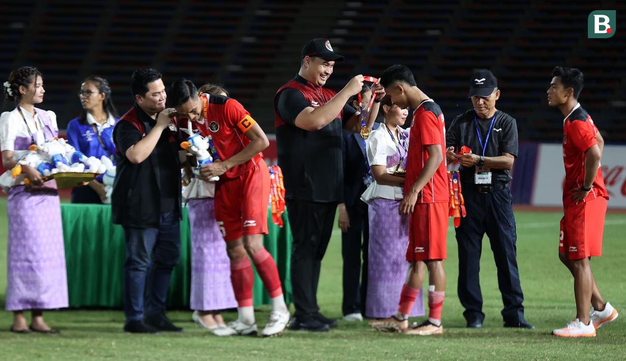 <p>Pemain Timnas Indonesia U-22, Rizki Ridho (empat dari kiri) dan Marselino Ferdinan (tiga dari kanan) saat menerima medali emas setelah memenangkan laga final sepak bola SEA Games 2023 melawan Thailand di Olympic Stadium, Phnom Penh, Kamboja, Selasa (16/05/2023). (Bola.com/Abdul Aziz)</p>