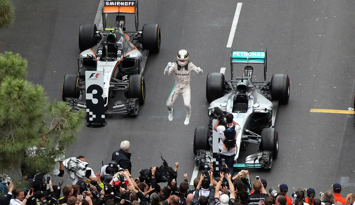Pembalap Lewis Hamilton melakukan selebrasi di dalam sirkuit usai berhasil menjuarai Grand Prix di Monaco, (29/5). Ditempat kedua  pembalap Red Bull Daniel Ricciardo dan pembalap Force India, Sergio Perez, di tempat ketiga. (AFP PHOTO/Valery Hache)