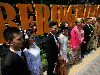 Sejumlah Calon pasangan mempelai foto bersama usai mengikuti fashion show busana pengantin di Pasar Beringharjo, Yogyakarta (3/2). Busana akan di pakai saat nikah massal yang akan di gelar 4 April 2016. (Liputan6.com/Boy Harjanto)