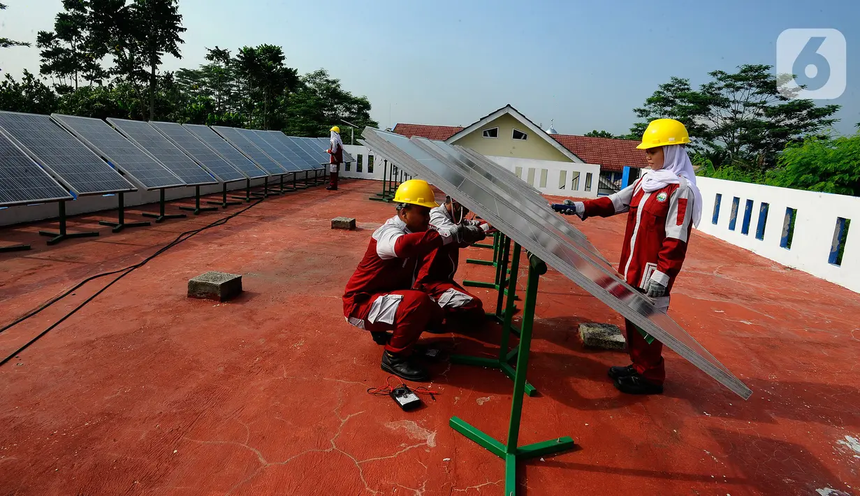 Siswa kompetensi keahlian Teknik Energi Surya Hidro dan Angin (TESHA) melakukan praktek perawatan solar panel di SMK Negeri 1 Kemang Bogor, Jawa Barat, Kamis (19/5/2022). Solar panel teserbut selain sebagai media pembelajaran siswa juga menghasilkan energi listrik yang digunakan untuk kebutuhan pasokan listrik di lab sekolah tersebut. (merdeka.com/Arie Basuki)