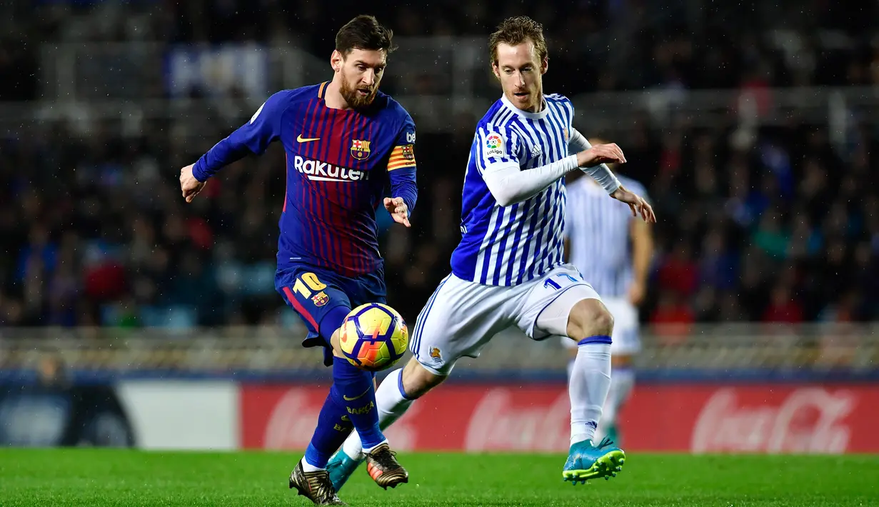 Pemain Barcelona, Lucas Digne berebut bola dengan kiper Real Sociedad, David Zuturuza pada laga pekan ke-19 La Liga di Stadion Anoeta, Minggu (14/1). Kemenangan berhasil diraih Barcelona 4-2 saat menghadapi Real Sociedad. (AP/Alvaro Barrientos)