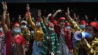 Para pengunjuk rasa mengacungkan salam tiga jari saat demonstrasi menentang kudeta militer di Yangon, Myanmar pada Sabtu (6/2/2021). Penangkapan Suu Kyi dan para pemimpin senior lainnya minggu ini menghentikan pemerintahan demokrasi selama 10 tahun terakhir. (YE AUNG THU / AFP)