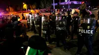 Polisi anti huru hara mencoba untuk membubarkan para demonstran yang ricuh saat kampanye Trump di Costa Mesa (Reuters)