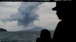 Personel TNI Angkatan Laut menyaksikan Gunung Anak Krakatau yang memuntahkan material vulkanik di perairan Selat Sunda (28/12). Pihak berwenang mengatakan pencarian korban terdampak tsunami akan berlanjut hingga Januari. (AP Photo/Fauzy Chaniago)