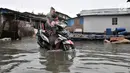 Pengendara motor menerobos banjir rob yang menggenangi permukiman Muara Angke, Jakarta, Selasa (22/1). Banjir air laut pasang atau Rob kembali melanda kawasan itu sejak 6 hari lalu membuat aktivitas warga terganggu. (Merdeka.com/Iqbal S. Nugroho)