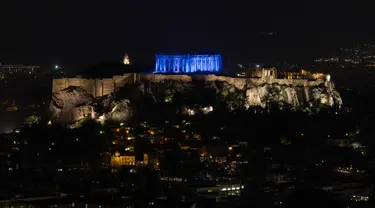 Situs warisan dunia Kuil Parthenon berwarna biru saat Hari Anak Sedunia, Athena, Yunani, Rabu (20/11/2019). Nuansa biru pada kuil yang berada di puncak bukit Acropolis tersebut untuk memperingati Hari Anak Sedunia yang jatuh setiap tanggal 20 November. (AP Photo/Petros Giannakouris)