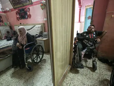 Nihad Jarboa (37) dan istrinya Zeinab (35), warga Palestina yang hidup dengan cacat fisik sejak masa kanak-kanak berada di rumah mereka di kamp pengungsi Rafah di Jalur Gaza selatan, pada 19 Juli 2020.  Suami dan istri tersebut tinggal dengan dua anaknya di rumah satu kamar. (AFP Photo/Said Khatib)