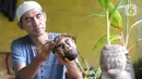 Seniman, Herman Ronda (49) mengukir bibit pohon kelapa yang dijadikan bonsai di Pondok Benda Pamulang, Tangerang Selatan, Selasa (13/10/2020). Budidaya bonsai tanaman kelapa semakin digemari untuk memanfaatkan waktu dengan harga mulai dari Rp 250 ribu hingga Rp 500 ribu. (merdeka.com/Dwi Narwoko)