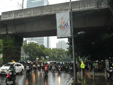 Pengendara sepeda motor berteduh di bawah flyover saat hujan turun, Jakarta, Rabu (13/7). Petugas kepolisian akan menerapkan tilang dengan denda maksimal Rp250.000 untuk pengendara yang berteduh di bawah flyover. (Liputan6.com/Gempur M Surya) 