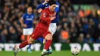 Gelandang Liverpool, Takumi Minamino menggiring bola dari kawalan pemain Everton, Gylfi Sigurdsson pada pertandingan babak ketiga Piala FA di Anfield, Minggu (5/1/2020). Pemain Jepang menjalani debut bersama Liverpool dengan menjadi starter dipertandingan tersebut. (AFP/Paul Ellis)