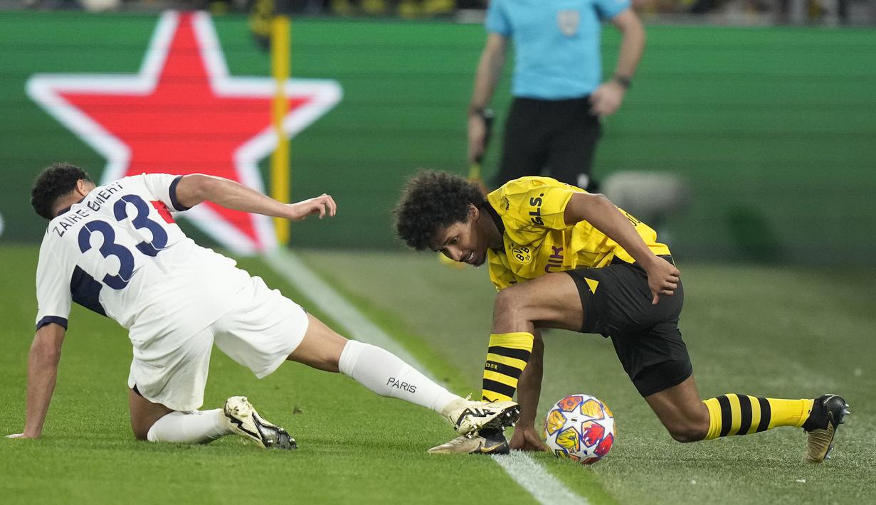 Striker Borussia Dortmund, Karim Adeyemi (kanan) berebut bola dengan gelandang PSG, Warren Zaire-Emery pada laga leg pertama semifinal Liga Champions 2023/2024 di Signal Iduna Park Stadium, Dortmund, Rabu (1/5/2024). (AP Photo/Matthias Schrader)