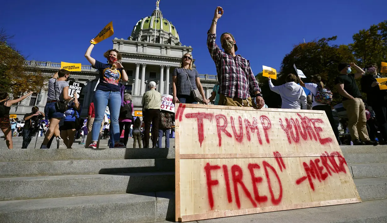 Orang-orang merayakannya kemenangan Joe Biden dalam Pilpres AS 2020 di luar Gedung Kongres Pennsylvania, Harrisburg, Pennsylvania, Amerika Serikat, Sabtu (7/11/2020). Calon presiden dari Partai Demokrat tersebut keluar sebagai pemenang dan akan menjadi presiden AS ke-46. (AP Photo/Julio Cortez)
